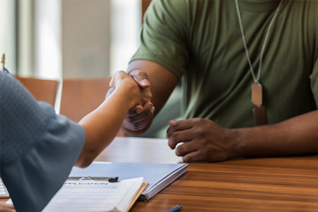Military student shakes hands in a meeting