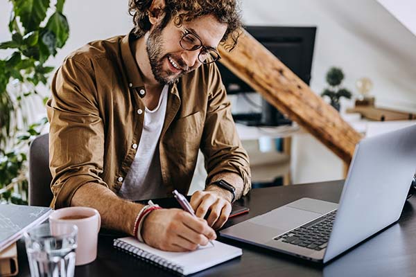 Online student takes notes from a laptop