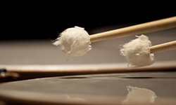 Close-up of mallets hitting drum heads