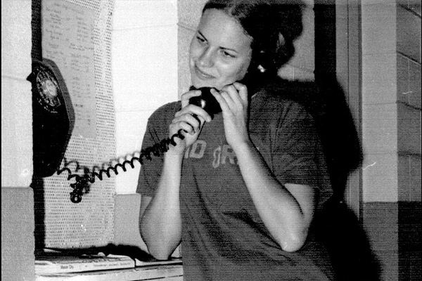 Black & White photo of a Waldorf College alum talking on an old rotary phone.