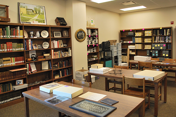 Room with tables, chairs and bookshelves full of archived pieces of Waldorf history